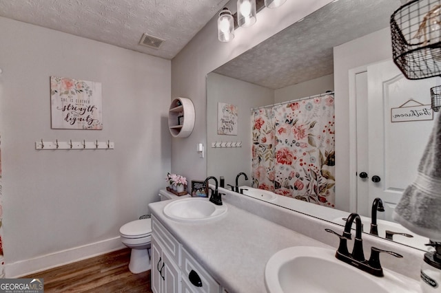 1882 Flowering Dr, Grayson, GA 30017 - full bath featuring wood finished floors, double vanity, baseboards, toilet, and a textured ceiling