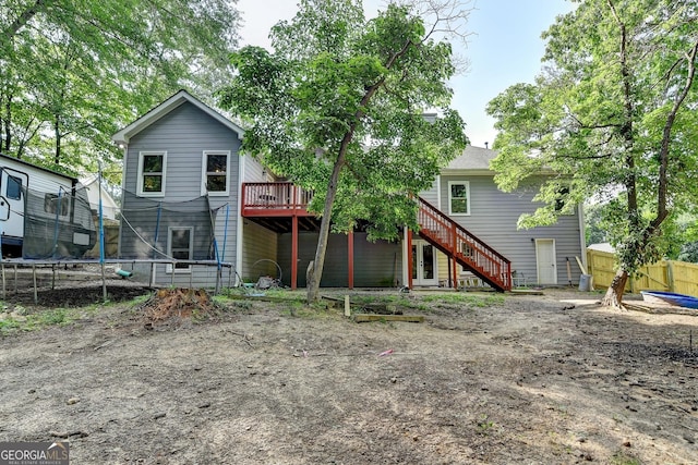 1882 Flowering Dr, Grayson, GA 30017 - back of property with a trampoline, a wooden deck, and stairway