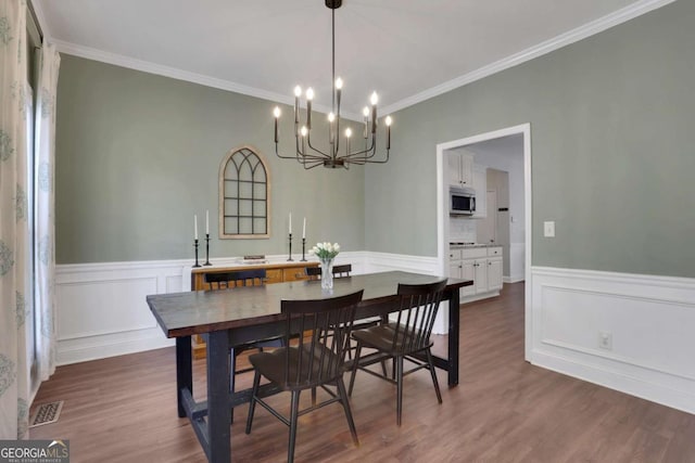 3980 Suwanee Place Dr, Suwanee, GA 30024 - dining room with ornamental molding, a chandelier, dark wood-style flooring, and a wainscoted wall