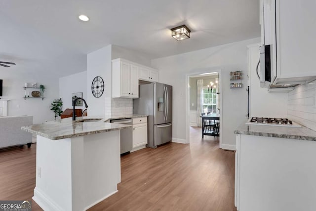 3980 Suwanee Place Dr, Suwanee, GA 30024 - kitchen with appliances with stainless steel finishes, a sink, a peninsula, open floor plan, and decorative backsplash