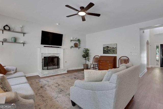 3980 Suwanee Place Dr, Suwanee, GA 30024 - living area featuring ceiling fan, a premium fireplace, arched walkways, and dark wood-style flooring
