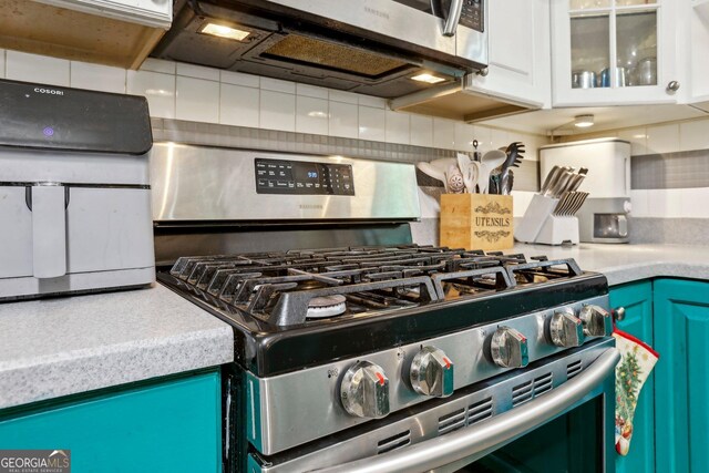 135 Clubhouse Dr NW, Kennesaw, GA 30144 - kitchen featuring stainless steel appliances, backsplash, light countertops, and glass insert cabinets