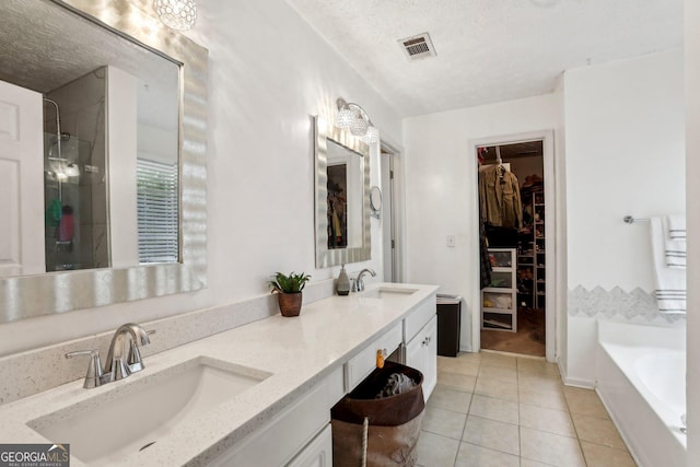 135 Clubhouse Dr NW, Kennesaw, GA 30144 - full bath featuring a textured ceiling, tile patterned floors, double vanity, a bath, and a walk in closet