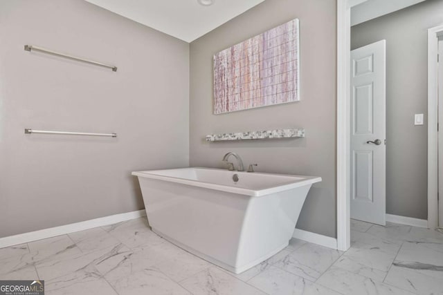 8045 Depford Way, Cumming, GA 30041 - bathroom with marble look tiles, baseboards, and a freestanding tub