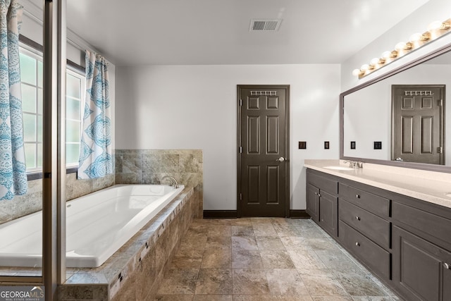 5995 Wellington Ave, Gainesville, GA 30506 - bathroom featuring plenty of natural light, double vanity, a garden tub, and stone finish flooring