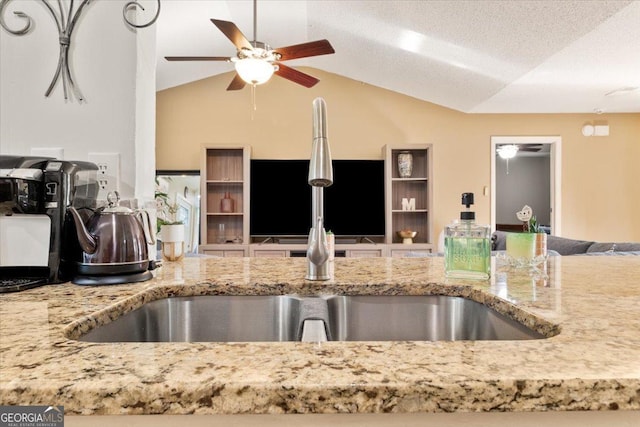 160 Country Mill Ln, Stockbridge, GA 30281 - kitchen featuring a ceiling fan, open floor plan, vaulted ceiling, light stone counters, and a sink
