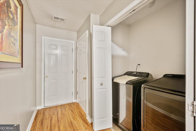 160 Country Mill Ln, Stockbridge, GA 30281 - washroom featuring washing machine and clothes dryer, light wood finished floors, baseboards, and a textured ceiling