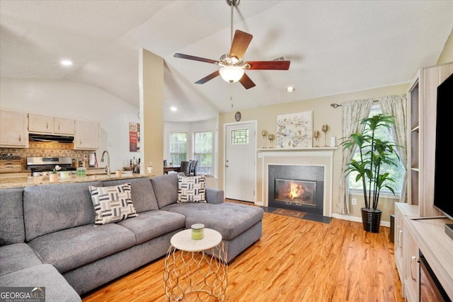160 Country Mill Ln, Stockbridge, GA 30281 - living area featuring light wood-style flooring, a fireplace with flush hearth, a ceiling fan, vaulted ceiling, and recessed lighting