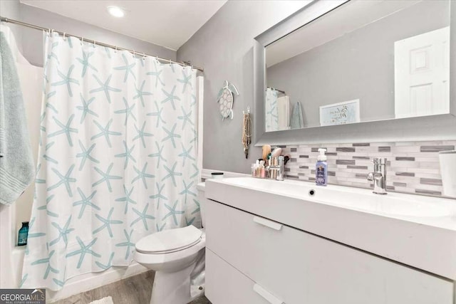 242 Sandhurst Ct, Suwanee, GA 30024 - bathroom featuring vanity, toilet, decorative backsplash, wood finished floors, and a shower with curtain