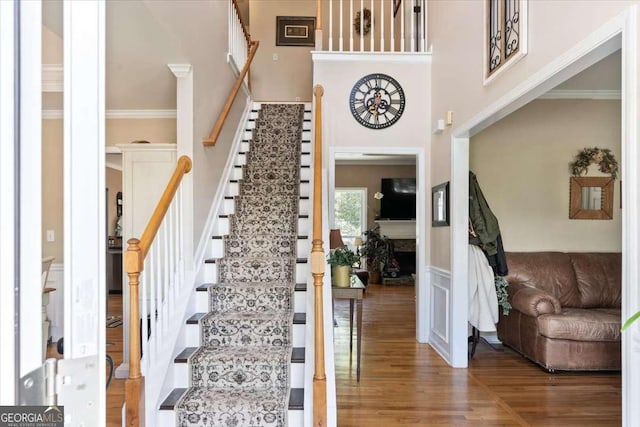 242 Sandhurst Ct, Suwanee, GA 30024 - staircase with wood finished floors, ornamental molding, and a high ceiling