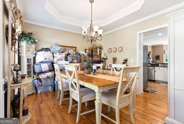 242 Sandhurst Ct, Suwanee, GA 30024 - dining space featuring a chandelier, light wood-style floors, crown molding, and a raised ceiling