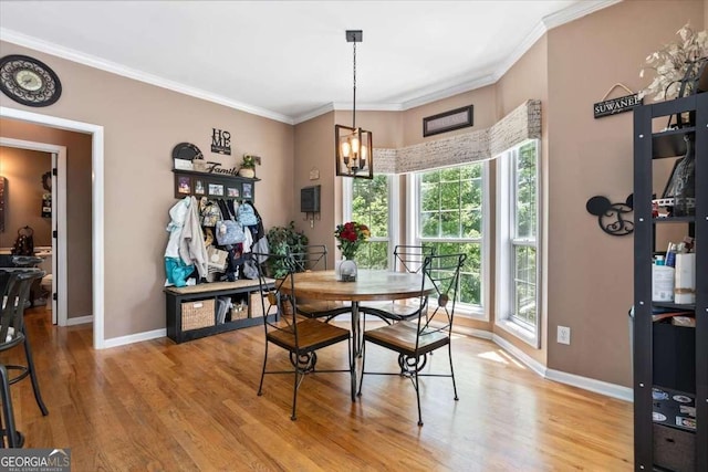 242 Sandhurst Ct, Suwanee, GA 30024 - dining area featuring baseboards, a chandelier, light wood-style floors, and crown molding
