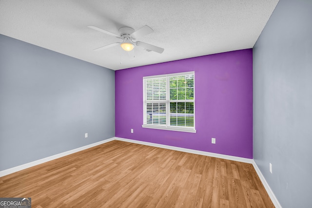 464 Old Camp Creek Rd, Cornelia, GA 30531 - spare room with wood finished floors, a textured ceiling, a ceiling fan, and baseboards