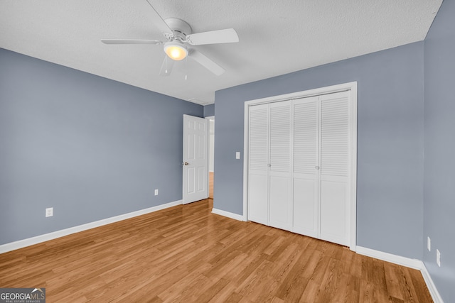 464 Old Camp Creek Rd, Cornelia, GA 30531 - unfurnished bedroom featuring light wood finished floors, a closet, baseboards, ceiling fan, and a textured ceiling