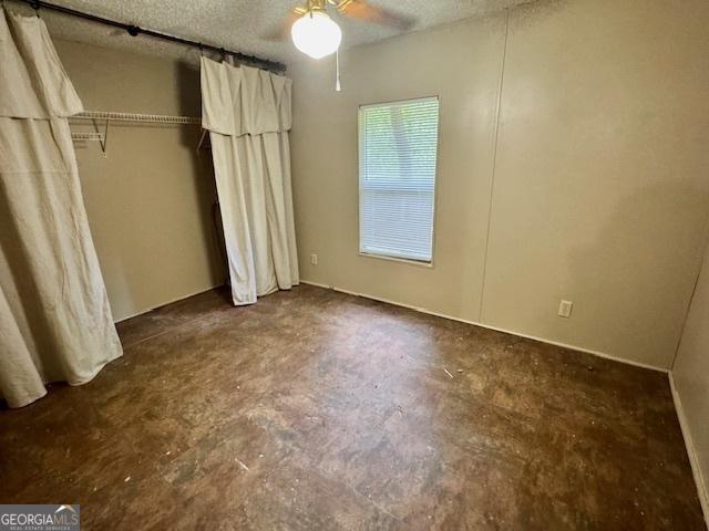 567 Anderson Parrish Rd, Portal, GA 30450 - unfurnished bedroom with concrete floors, a textured ceiling, and a ceiling fan