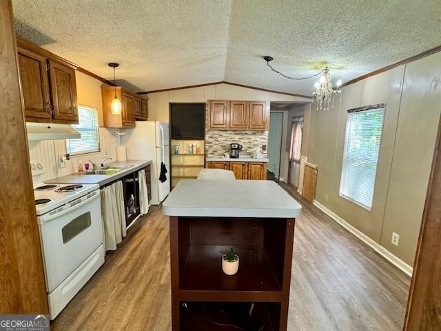567 Anderson Parrish Rd, Portal, GA 30450 - kitchen featuring white appliances, light wood-type flooring, vaulted ceiling, a chandelier, and brown cabinets