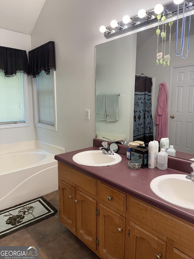 1432 Eagles Nest Cir, Carrollton, GA 30116 - bathroom featuring double vanity, a garden tub, vaulted ceiling, and tile patterned flooring