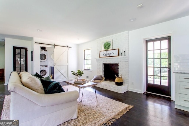 6715 Wright Rd, Sandy Springs, GA 30328 - living room with stacked washing machine and dryer, a barn door, dark wood finished floors, a brick fireplace, and recessed lighting