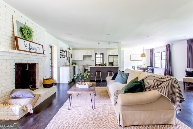 6715 Wright Rd, Sandy Springs, GA 30328 - living area featuring healthy amount of natural light, dark wood finished floors, and a brick fireplace