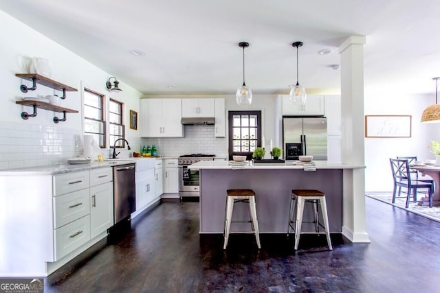 6715 Wright Rd, Sandy Springs, GA 30328 - kitchen featuring stainless steel appliances, backsplash, a breakfast bar, white cabinetry, and recessed lighting