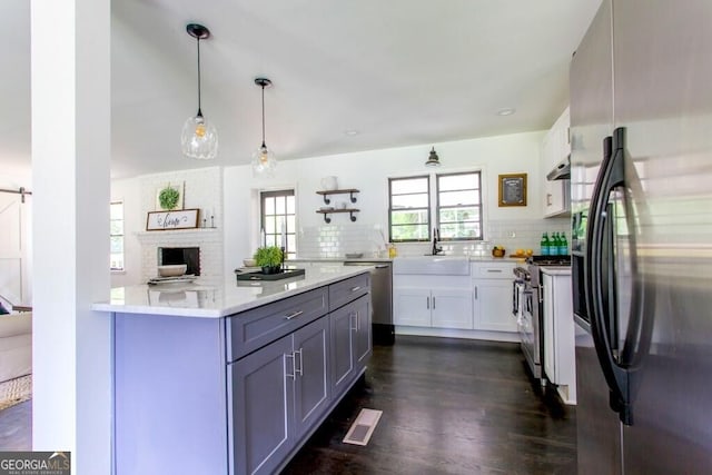 6715 Wright Rd, Sandy Springs, GA 30328 - kitchen featuring stainless steel appliances, backsplash, white cabinetry, dark wood-style flooring, and decorative light fixtures
