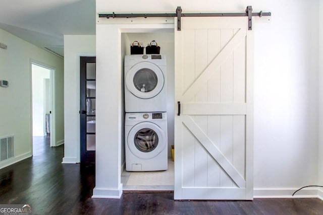 6715 Wright Rd, Sandy Springs, GA 30328 - laundry area with stacked washing machine and dryer, dark wood-type flooring, and a barn door