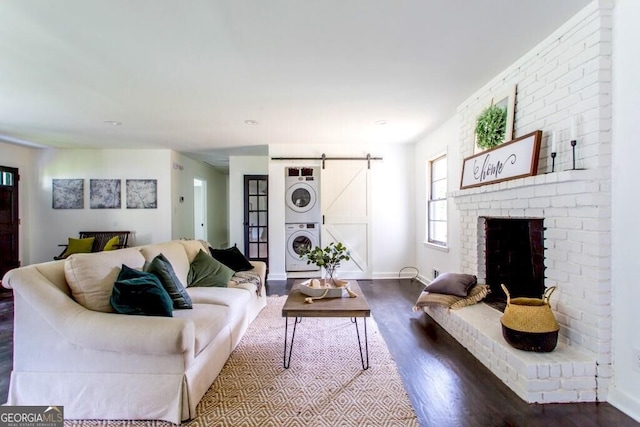 6715 Wright Rd, Sandy Springs, GA 30328 - living room featuring stacked washing machine and dryer, dark wood-style floors, a barn door, a fireplace, and recessed lighting