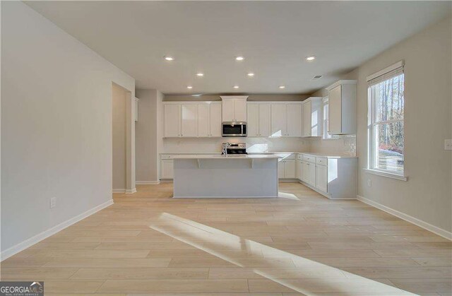 2525 Dixon Pl, Lawrenceville, GA 30045 - kitchen with appliances with stainless steel finishes, baseboards, white cabinets, light wood-type flooring, and recessed lighting