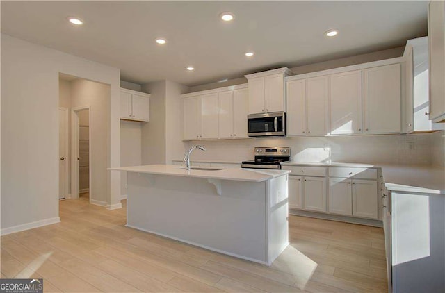 2525 Dixon Pl, Lawrenceville, GA 30045 - kitchen featuring appliances with stainless steel finishes, a sink, light wood finished floors, recessed lighting, and tasteful backsplash