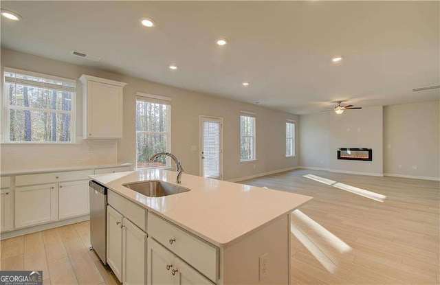 2525 Dixon Pl, Lawrenceville, GA 30045 - kitchen featuring a sink, dishwasher, light wood finished floors, ceiling fan, and light countertops