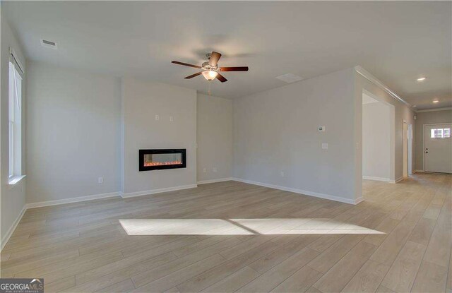 2525 Dixon Pl, Lawrenceville, GA 30045 - unfurnished living room featuring ceiling fan, light wood-style floors, baseboards, a glass covered fireplace, and recessed lighting
