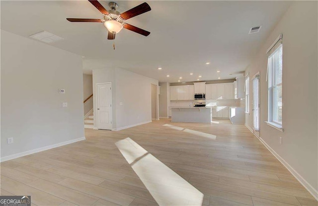 2525 Dixon Pl, Lawrenceville, GA 30045 - unfurnished living room featuring light wood-style floors, ceiling fan, stairway, baseboards, and recessed lighting