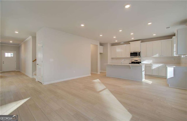 2525 Dixon Pl, Lawrenceville, GA 30045 - kitchen with stainless steel appliances, white cabinetry, baseboards, a center island with sink, and recessed lighting
