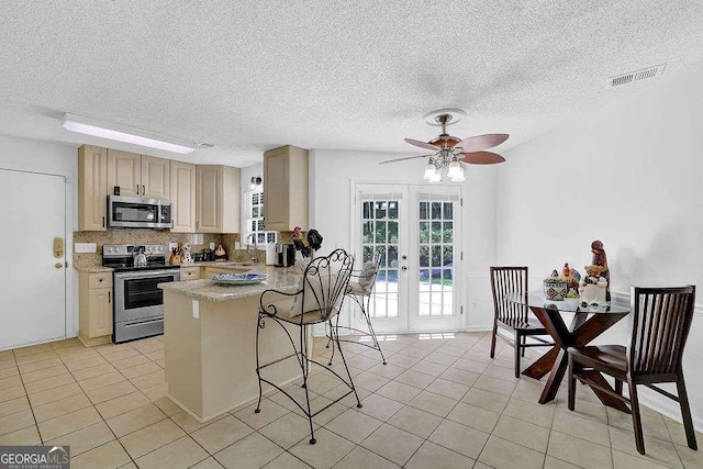 985 Laurel Springs Ln, Marietta, GA 30064 - kitchen with appliances with stainless steel finishes, a peninsula, ceiling fan, light countertops, and french doors