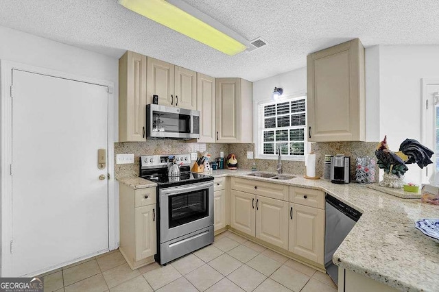985 Laurel Springs Ln, Marietta, GA 30064 - kitchen featuring stainless steel appliances, backsplash, light tile patterned flooring, a textured ceiling, and light stone counters