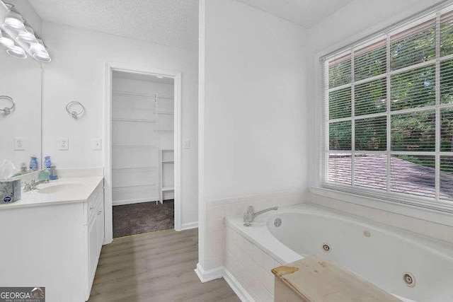 985 Laurel Springs Ln, Marietta, GA 30064 - full bath with vanity, a whirlpool tub, wood finished floors, a spacious closet, and a textured ceiling
