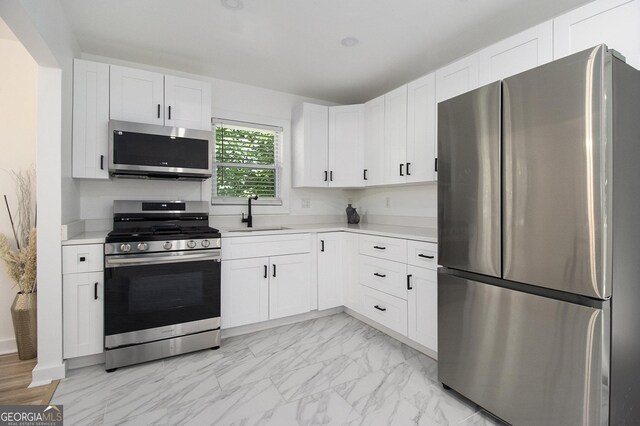 2537 Baker Rd NW, Atlanta, GA 30318 - kitchen with stainless steel appliances, a sink, light countertops, and white cabinetry