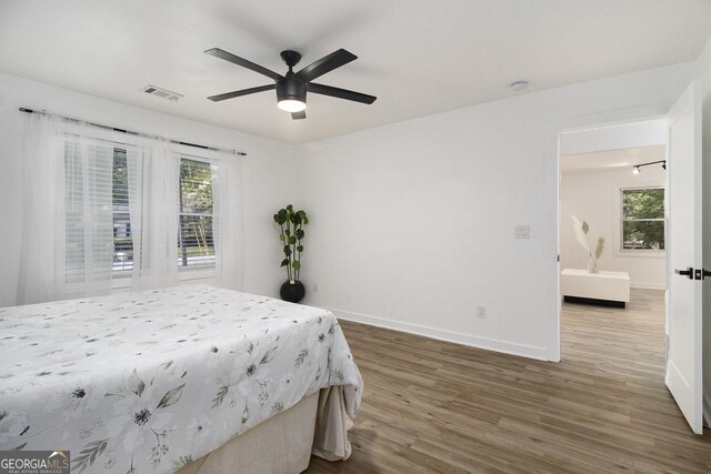 2537 Baker Rd NW, Atlanta, GA 30318 - bedroom featuring wood finished floors, baseboards, multiple windows, and ceiling fan