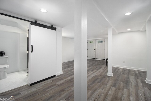 2537 Baker Rd NW, Atlanta, GA 30318 - below grade area featuring dark wood-style floors, a barn door, baseboards, and recessed lighting