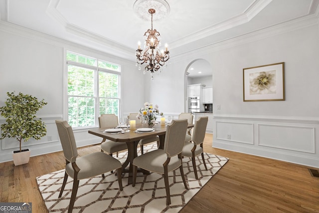 576 Cliftwood Ct, Sandy Springs, GA 30328 - dining area with arched walkways, light wood finished floors, a chandelier, wainscoting, and ornamental molding