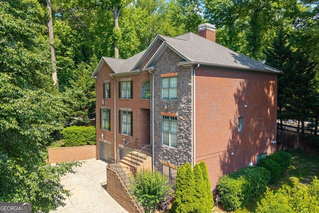 576 Cliftwood Ct, Sandy Springs, GA 30328 - view of front of house featuring concrete driveway, a chimney, a garage, stone siding, and brick siding