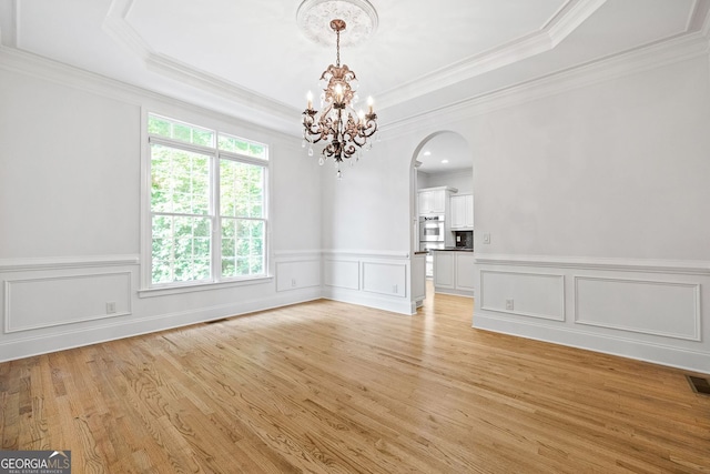 576 Cliftwood Ct, Sandy Springs, GA 30328 - empty room with a chandelier, arched walkways, light wood-type flooring, crown molding, and a raised ceiling