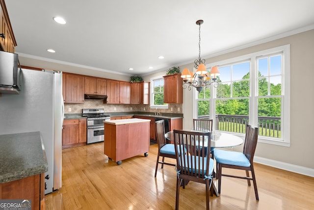 541 Brown Dr, Clermont, GA 30527 - kitchen featuring appliances with stainless steel finishes, under cabinet range hood, a chandelier, a kitchen island, and ornamental molding