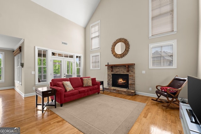 541 Brown Dr, Clermont, GA 30527 - living area with high vaulted ceiling, light wood-style floors, french doors, baseboards, and a stone fireplace