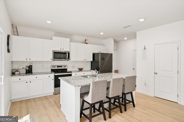 218 Lookout Dr, Dallas, GA 30132 - kitchen featuring stainless steel appliances, decorative backsplash, light wood-style floors, and recessed lighting