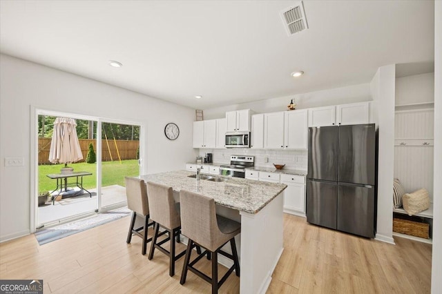 218 Lookout Dr, Dallas, GA 30132 - kitchen featuring appliances with stainless steel finishes, white cabinets, light wood-type flooring, and recessed lighting