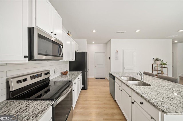 218 Lookout Dr, Dallas, GA 30132 - kitchen featuring stainless steel appliances, white cabinetry, a kitchen island with sink, recessed lighting, and backsplash