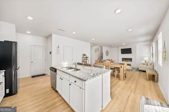 218 Lookout Dr, Dallas, GA 30132 - kitchen featuring freestanding refrigerator, a fireplace, white cabinetry, dishwasher, and light wood finished floors