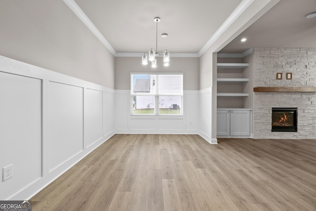 272 Broadstone Blvd, Acworth, GA 30101 - unfurnished dining area featuring a decorative wall, wood finished floors, built in shelves, ornamental molding, and a stone fireplace