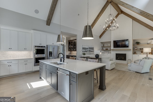 4781 Falling Brook Dr, Flowery Branch, GA 30542 - kitchen featuring stainless steel appliances, a sink, beamed ceiling, high vaulted ceiling, and white cabinets